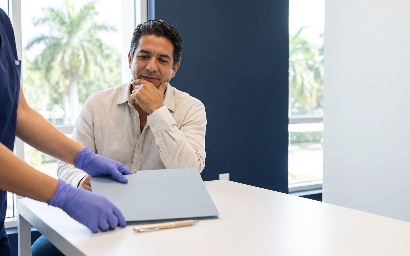 Hair transplant consultation with blank folder and pen on a white desk
