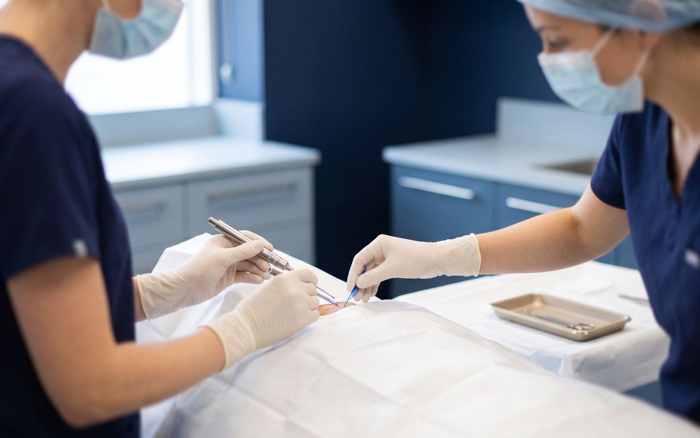 Hair transplant surgeons arranging Choi implanter pen and sapphire blade on sterile table