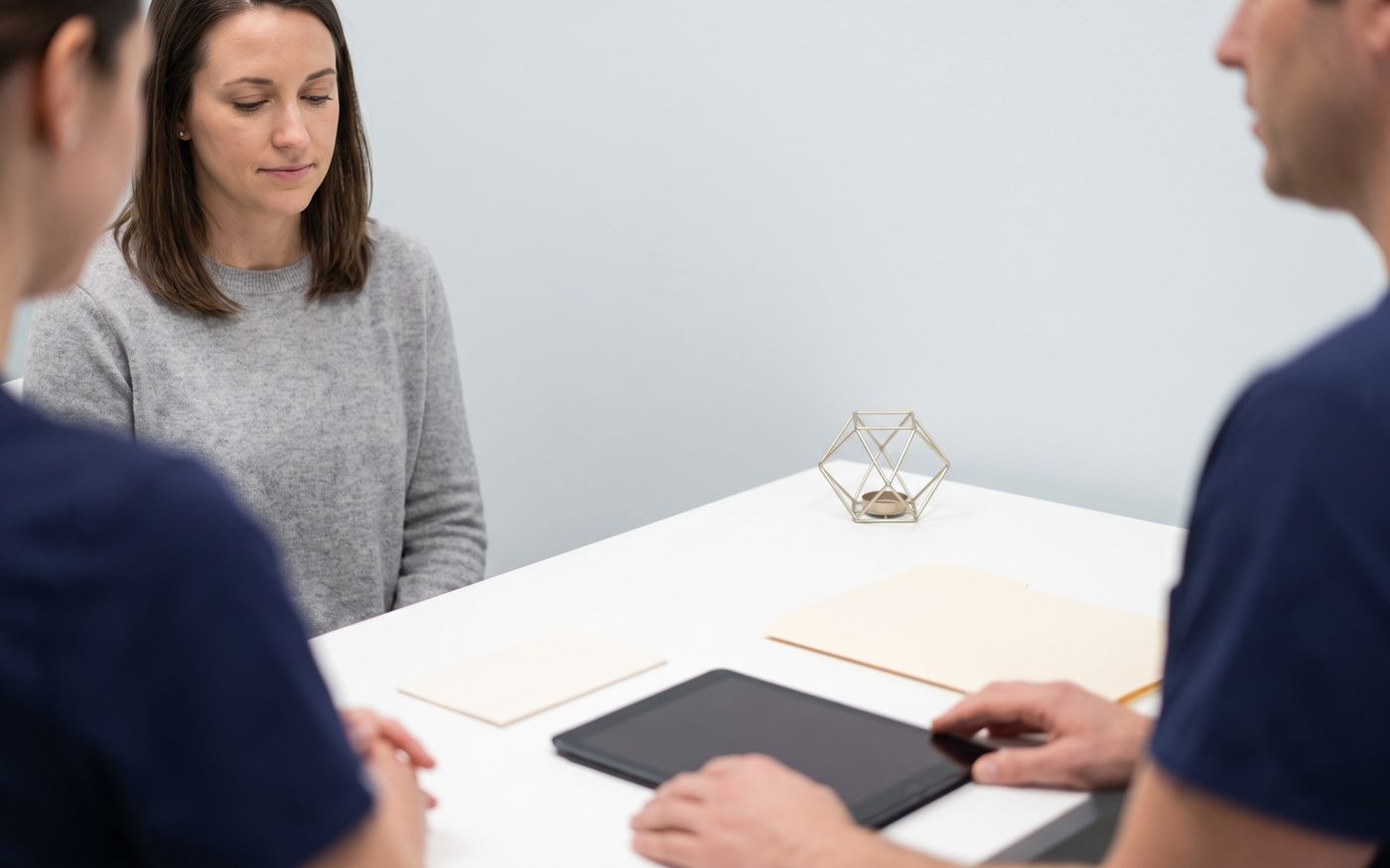 Woman and advisor with blank tablet during female hair transplant financing consultation