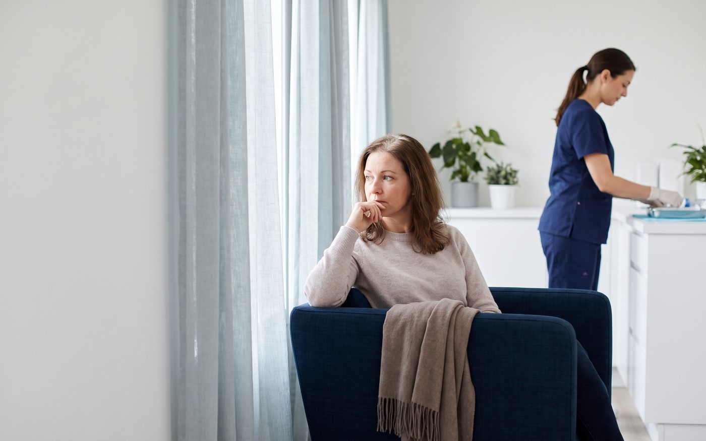Woman with diffuse part thinning seated by window during PRP Therapy consultation