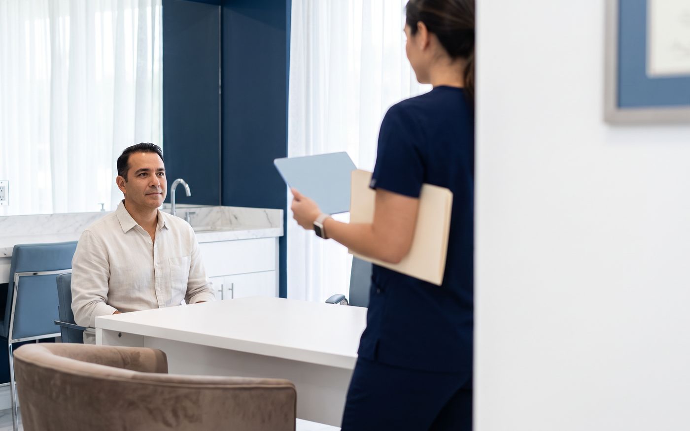 Hair transplant cost consultation with patient reviewing a blank tablet